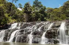 Cachoeira em degraus de pedra cercada por mata