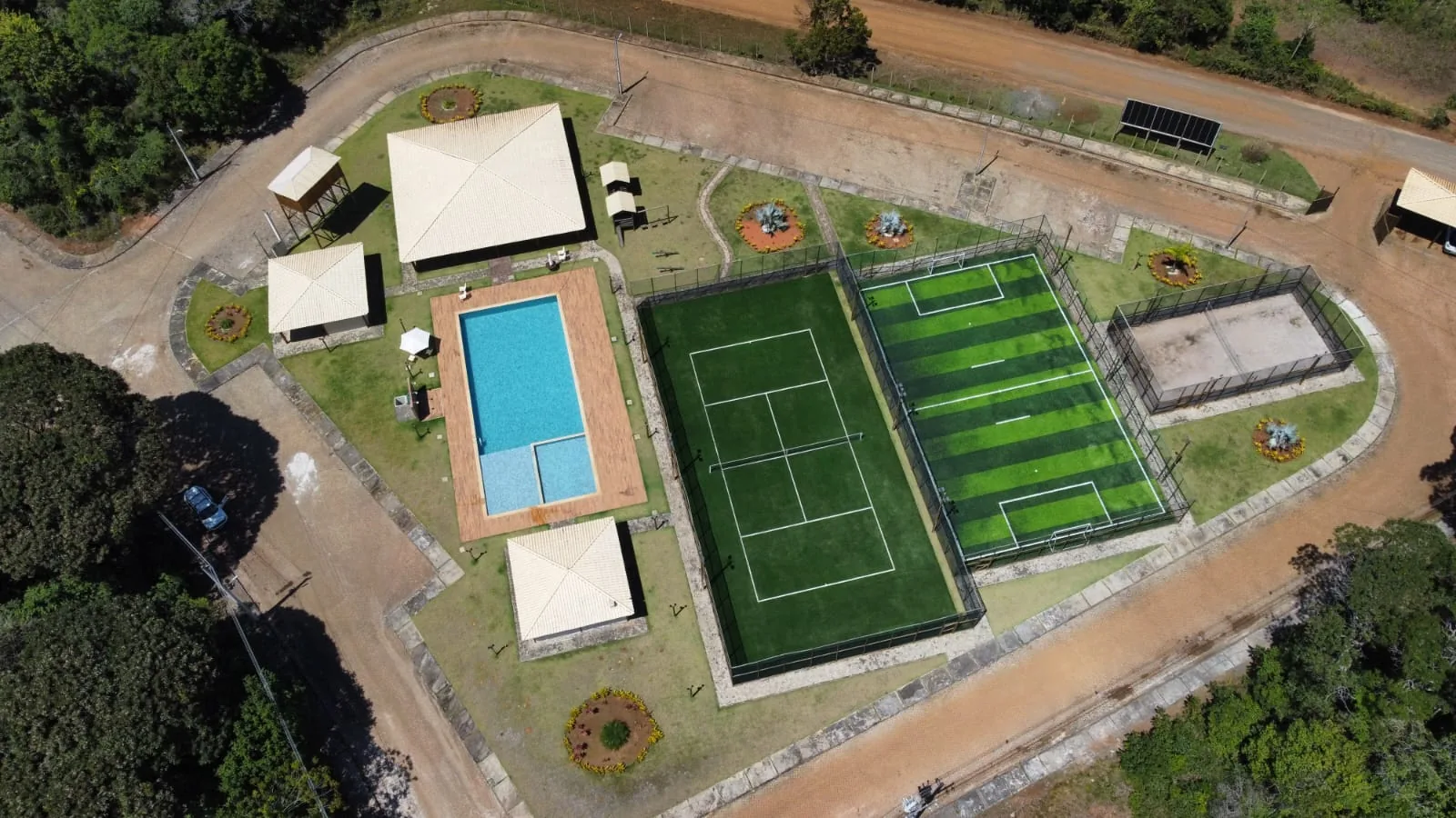 Vista aérea de cima da piscina e das quadras esportivas